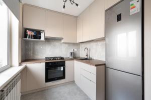 阿拉木图Two Bedroom Apartment In The Center of Almaty的厨房配有白色橱柜、水槽和炉灶。