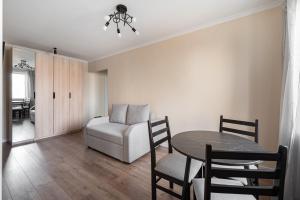 阿拉木图Two Bedroom Apartment In The Center of Almaty的客厅配有桌子和白色沙发