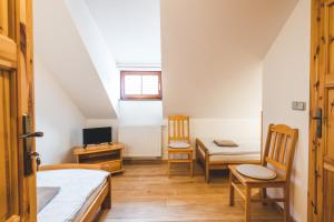 捷克克鲁姆洛夫Pension Krumau的客房设有两张床、一张桌子和一台电视机。