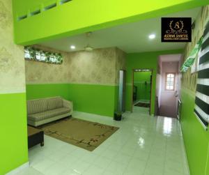 马六甲ASTANA SHAFIIS的客厅设有绿色的墙壁和沙发