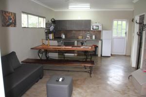 Dinokeng Game ReserveComfortable cottage in Big 5 Game Reserve的带沙发、桌子和冰箱的客厅