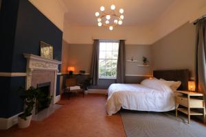 利物浦Eastfield的一间卧室配有一张床、一个壁炉和一个吊灯。