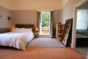 利物浦Eastfield的卧室配有床、浴缸和窗户。