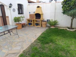 卡拉德米哈斯Chalet junto al mar con jardín privado的一个带桌子和比萨饼烤箱的庭院