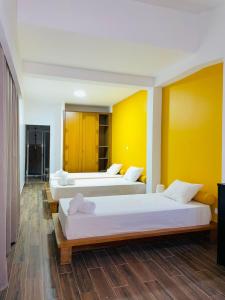 蓬塔杜索尔Residencial Sol Point Art的黄色墙壁客房的两张床