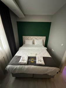 TalasZirve Suit Residance的一间卧室配有一张带绿色床头板的床