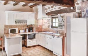 塔登Les 3 rossignols的厨房配有白色橱柜和白色冰箱。