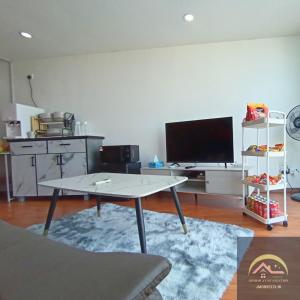 峇六拜Minimalist Duplex @ BayanLepas的客厅配有桌子和平面电视。