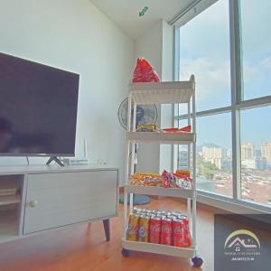 峇六拜Minimalist Duplex @ BayanLepas的一间配有电视的房间和一个带苏打水罐的架子