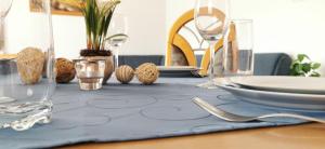 卡普伦Appartements Mary inklusive Tauern-Spa Kaprun的一张桌子,上面有蓝桌布,上面有盘子和眼镜
