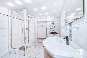 弗劳恩施泰因山Sonnenhaus的带淋浴和盥洗盆的白色浴室