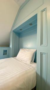 韦茅斯费尔赫维酒店的卧室配有白色床和蓝色墙壁