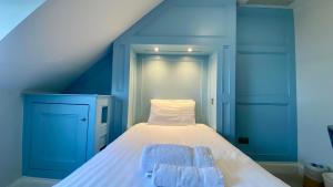 韦茅斯费尔赫维酒店的蓝色客房,配有带两条毛巾的床