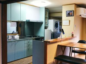 出云市Folksy House / Vacation STAY 64171的厨房配有蓝色橱柜和桌椅