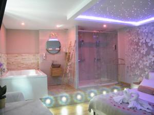 拉西约塔Studio Love Spa Baignoire XXL Port Vieux La Ciotat的粉红色的浴室设有淋浴、浴缸和水槽。