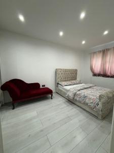 BradenhamCheerful 2 Bedroom Bungalow fully Furnished的一间卧室配有两张床和一张红色沙发