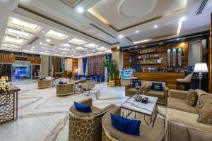 利雅德Crown Rose AlSahafa Hotel的带沙发和椅子的大堂以及酒吧