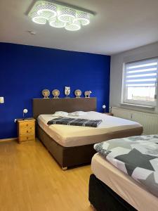 塔勒Ferienwohnungen Wotan的一间卧室设有两张床和蓝色的墙壁