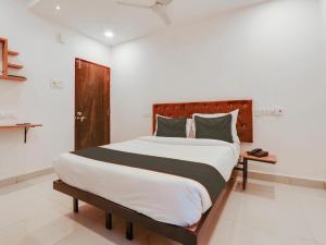 海得拉巴Super Collection O White Ridge Kamineni的一间卧室配有一张大床和木制床头板