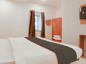 海得拉巴Super Collection O White Ridge Kamineni的卧室配有白色的床和窗户。