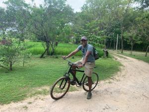 ButtalaSahana Retreat的土路上拿着自行车的人