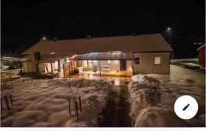 HolmestrandSea view Holmestrand sauna and hot tube appartment的夜晚有雪覆盖的房子