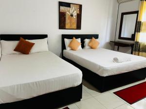 AmbalantotaSobaya Residence的小型客房配有两张床,