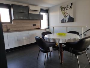 鲁西隆地区卡内L'Orlu Chambres D'Hotes proximité plage的厨房配有桌椅和一幅画画