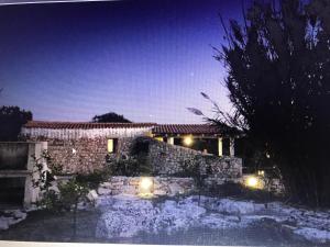 萨尔维Feudo Frammasi - Curte Glamping Experience的院子里晚上有灯的石头房子