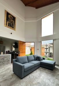卡尔卡Sacred Valley House的客厅设有蓝色的沙发和大窗户