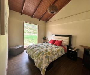 卡尔卡Sacred Valley House的一间卧室配有一张带红色枕头的床和一扇窗户