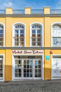 圣克鲁斯-德拉帕尔马圣特尔莫酒店的黄色的建筑,上面有读书漂亮的街道业力的标志