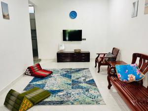 加央Sehijau Homestay Kangar的一间带电视和地毯的客厅