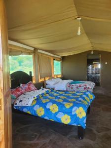 Sekenaniilkerin camp maasai mara的一间卧室,配有两张床