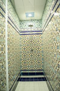 巴库Bulvar Inn Baku Hotel的浴室设有带淋浴的瓷砖墙