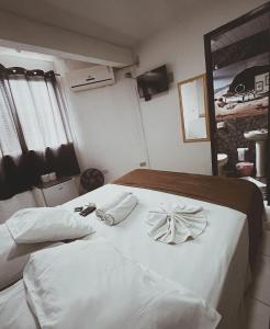 巴拉那州蓬塔尔Hotel Morada de Leste的卧室配有白色的床和2条毛巾