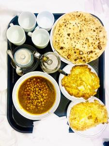 卡拉奇Airport Hotel Bed & Rest的配汤的食品托盘和一盘食品