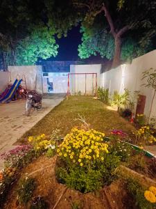 卡拉奇Airport Hotel Bed & Rest的鲜花盛开的花园以及夜间游乐场