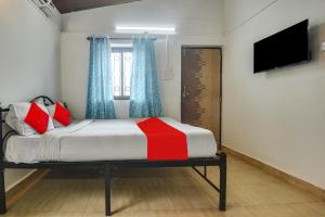 巴加OYO Pratisha Guest House的一间卧室设有一张带电视和窗户的床。