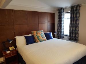波特兰高地酒店的卧室配有带蓝色枕头的大型白色床