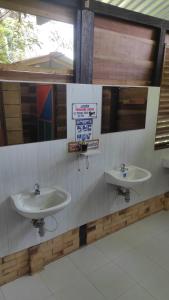 圣何塞德尔瓜维亚雷Ecopradera的浴室设有两个水槽和墙上的标志