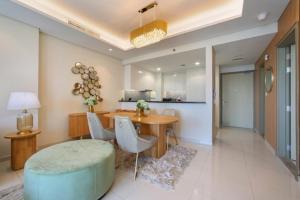 迪拜Luxurious one bedroom Apartment的一间带桌椅的客厅和一间厨房