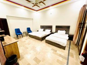 卡拉奇Airport Hotel Bed & Rest的一间卧室配有两张床和两张蓝色椅子