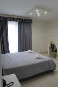 切萨雷奥港Hotel Presidente的一间卧室配有一张床,上面有两条毛巾