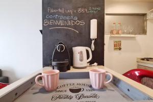 布宜诺斯艾利斯Loft encantador en el corazón de Núñez的厨房柜台,上面有两个咖啡杯