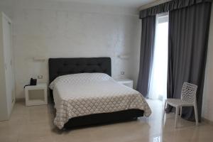 切萨雷奥港Hotel Presidente的卧室配有床、椅子和窗户。