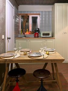 基希讷乌Tiny Barn House的厨房配有带酒杯的木桌