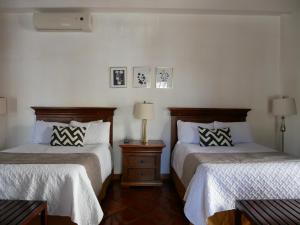 帕拉斯德拉富恩特Hotel El Farol的一间卧室配有两张床,还有一个床头柜和两盏灯。