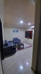 达瓦迪米شقق مساكن السمو المخدومة的客厅配有蓝色的沙发和电视