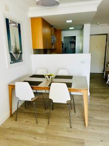 波里斯-德阿沃纳El Poris的一间带木桌和白色椅子的用餐室